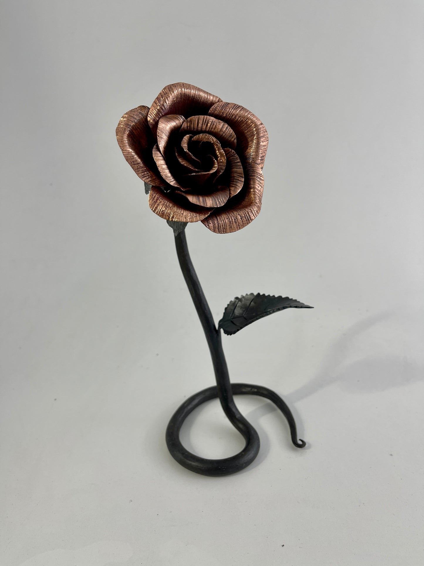 Copper and steel rose with scrolled base